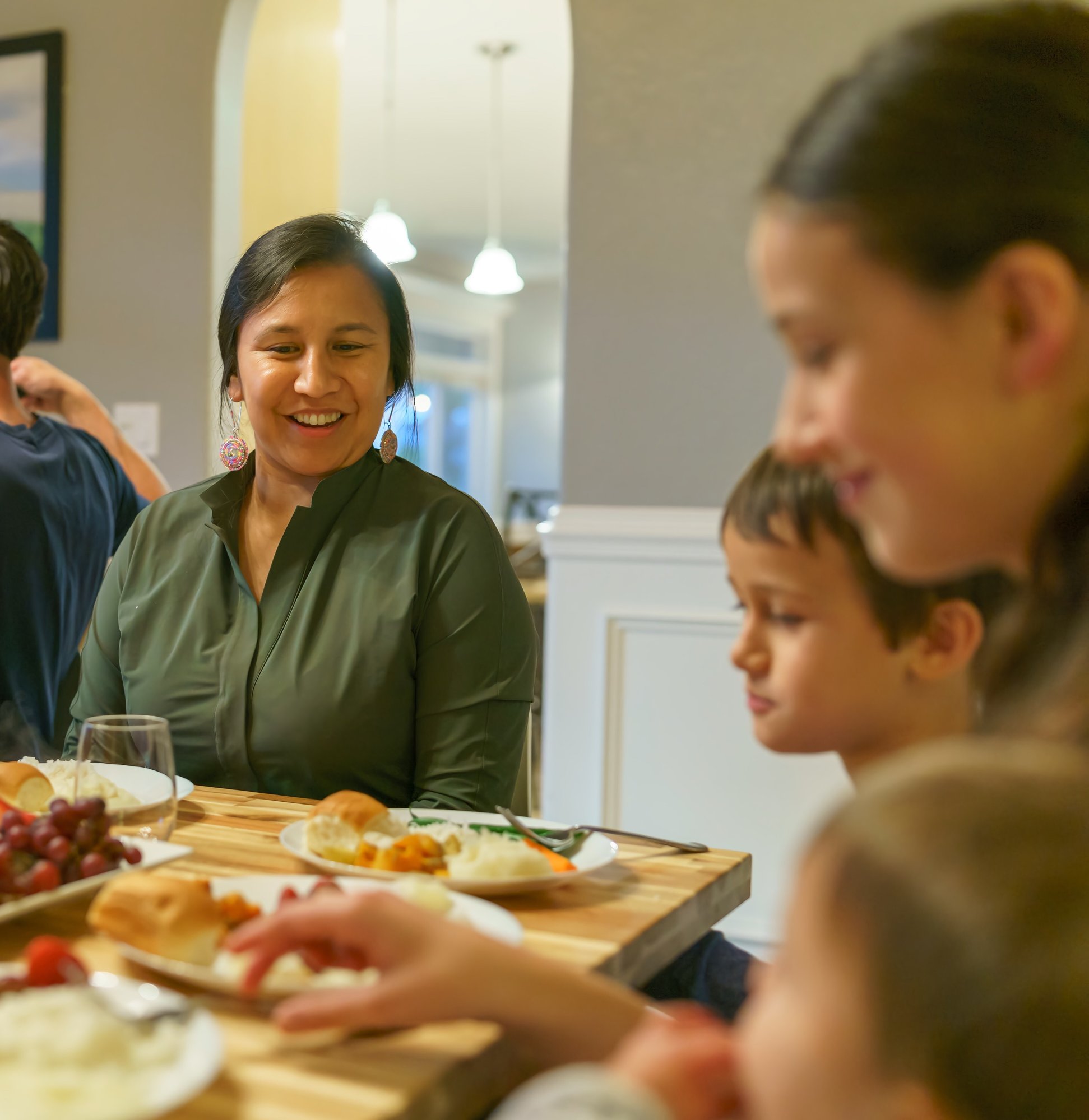 Native American woman eating dinner with her kids Native American woman eating dinner with her kids