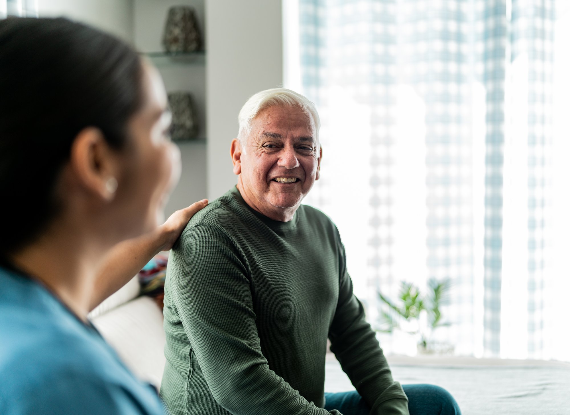 Older man in green shirt with nurse