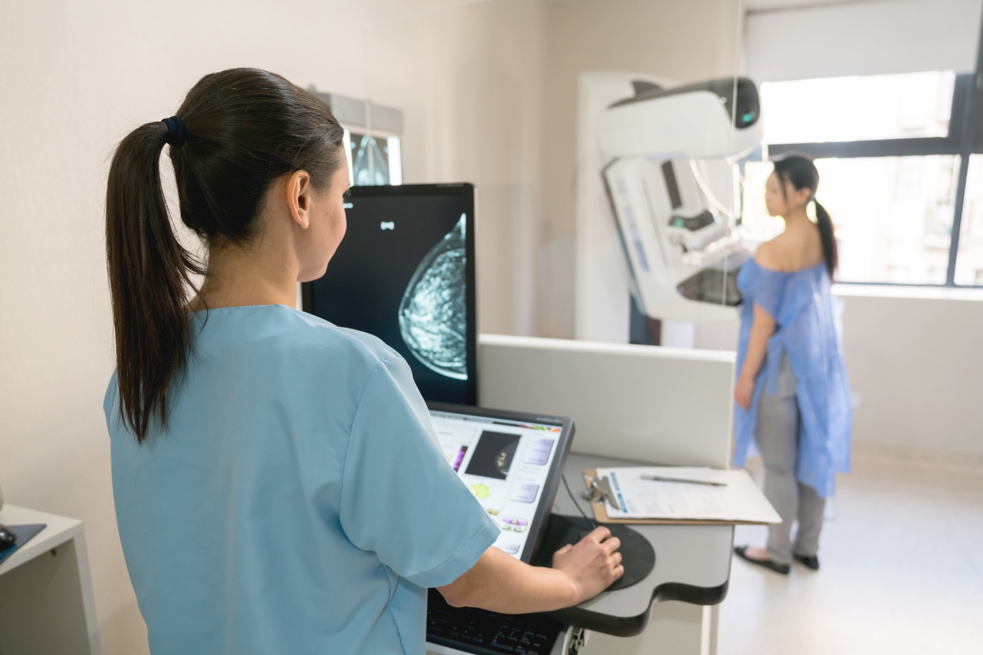 Nurse performing mammogram on patient Nurse performing mammogram on patient
