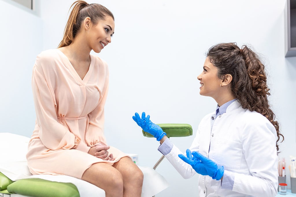 Doctor talking to woman in pink robe Doctor talking to woman in pink robe